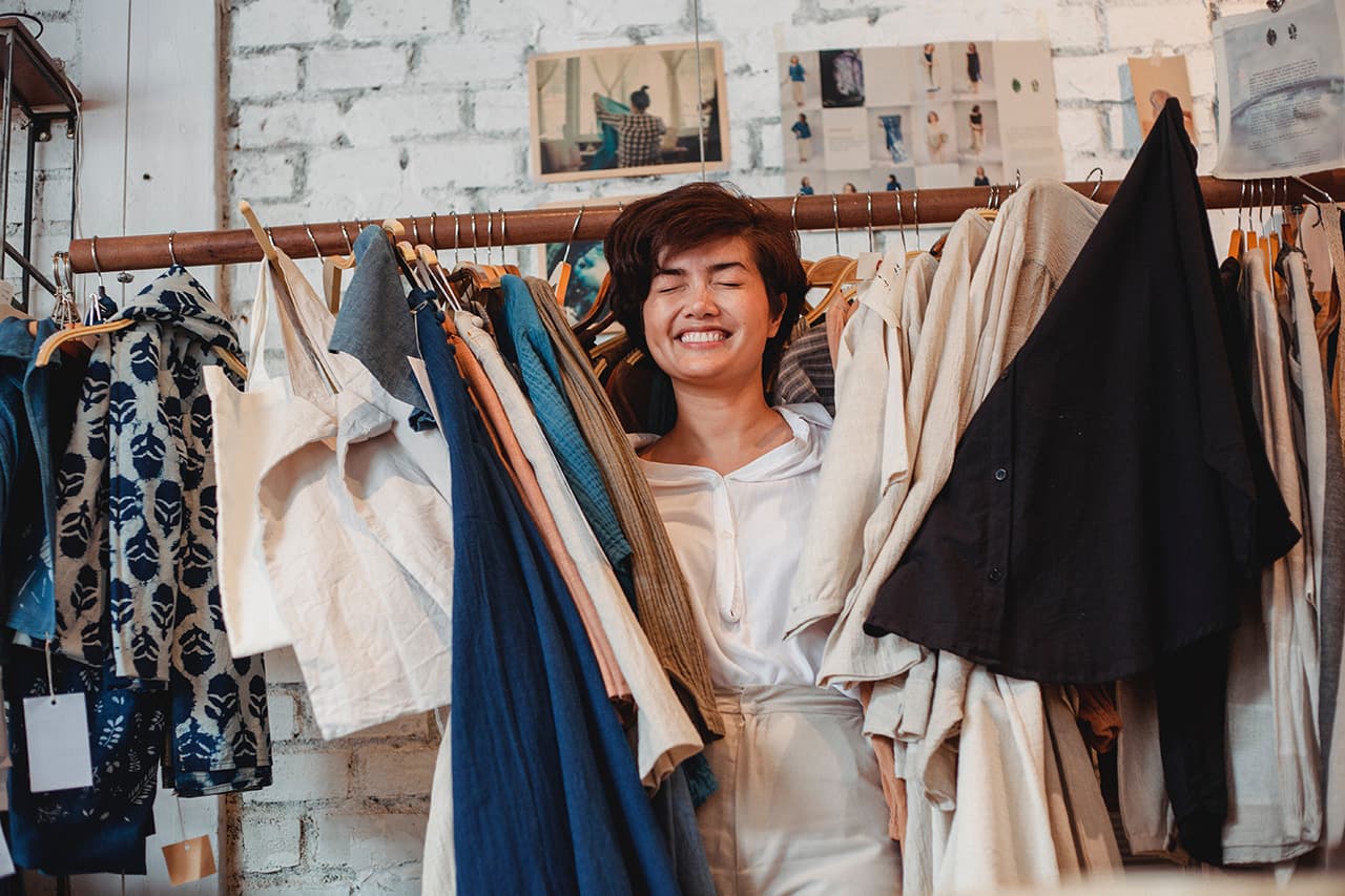 A customer having a great experience in store, a happy woman holding many garments